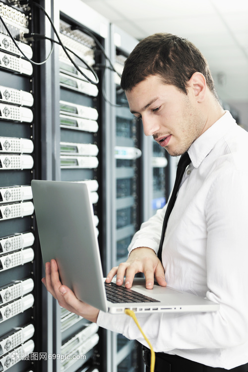 輕的IT工程師與商務人員 現代鋁制筆記本電腦與網絡服務器機房的融合